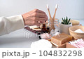 Natural bathroom and home spa tools. Zero waste sustainable concept. Woman hands drop in homemade DIY beauty products in reusable bottles on white background. Bamboo toothbrush, soap bar, cotton pads. 104832298