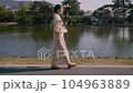 A woman walking with a camera in a yukata 104963889