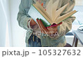 close-up, hands flipping through a book in slow motion, a woman in a blue jacket, a student in a coworking space preparing for exams or just reading 105327632