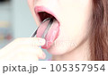 A woman cleans her tongue with a special scraper, close-up. 105357954