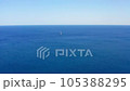 Aerial shot drone flies to lonely white sailboat sailing in open sea deep blue water on sunny day 105388295