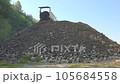 Dump truck unloading sand stone and gravel mix. Large big road material. Vehicle doing back maneuver. Broken shredded river bed stone. Lift damper transporting transport tipper old dirt stack 105684558
