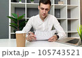 Young man reads and signs a contract in the office 105743521