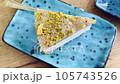 Serving piece of cheesecake with nut sprinkles, chocolate and lemon 105743526
