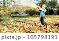 Father and son having fun in autumn park with fallen leaves, throwing up leaf. Child kid boy and his dad outdoors playing with maple leaves. 105798191