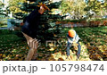 Father and son having fun in autumn park with fallen leaves, throwing up leaf. Child kid boy and his dad outdoors playing with maple leaves. 105798474