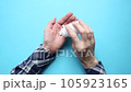 Man takes pills from a white jar. Blue background. Top view. Taking medication. Health care. Man pouring pills on his hand 105923165