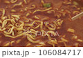 Picking up spicy ramen with chopsticks 106084717