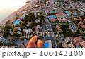 paraglider flying over roofs of houses with swimming pools and Smooth landing 106143100