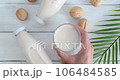 Hand taking a glass with walnut milk from table, vegan drink served on table, alternative milk, slow motion video, closeup video 106484585