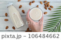 Person taking a glass with almond milk from table, vegan drink placed on table, alternative milk drink, slow motion video, close-up video 106484662