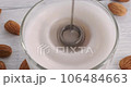 Making milk froth with electric milk foam maker, top view close-up video of automatic rotating milk frother quickly whipping vegan non-dairy drink made of almond nuts, 4k footage 106484663