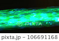 Stream of water illuminated by light rays of different colors macro 106691168