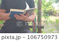 A man reads a book in the yard 106750973