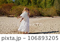 Mom spinning with her daughter and laughing on the sandy beach 106893205