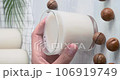 Macadamia milk, hand taking a glass of non-dairy drink made of macadamia nut, kitchen table on background, close-up video, hd vertical footage, slow motion video 106919749