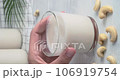 Cashew milk, person taking a glass of non-dairy drink made of cashew nuts from table, kitchen table on background, close-up video clip, 4k vertical footage 106919754
