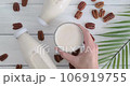 Person taking a glass with pecan milk from table, vegan drink served on table, alternative milk drink, slow motion video, close-up video 106919755