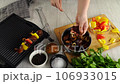 4k, Woman stacks a shish kebab in a grill on skewers at home. Electric grill, grilled meat, barbecue, kebab 106933015