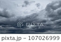 Dark gray thunder clouds. Countryside in rainy weather. Thunderous clouds in summer 107026999