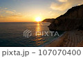 Evening background of the sea view, beach with people at sunset 107070400