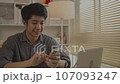 Young man typing chat/message on mobile phone with smiling face. Digital Communication, Conversation via smartphone of internet network. 107093247