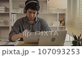 Studying online using a laptop, Man watching live video or video call of teacher teaching on laptop in her home, Take notes of important conversations and messages during the teacher's teaching.  107093253