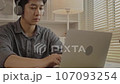 Man sat typing away on a laptop in his office with a determined look on his face, Work from the comfort of home, Male hand pressing on laptop keyboard, Work from home. 107093254