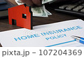Home insurance policy and hands counting out money. 107204369