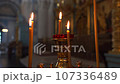 Lighted candles in an Orthodox church 107336489