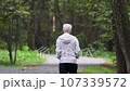 An elderly man walks in a forest park 107339572