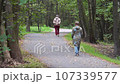 Woman walking in a forest park 107339577