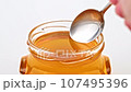 Dripping honey from spoon close up 107495396