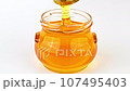 Dripping honey from spoon close up 107495403