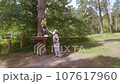A child in a forest adventure park made of ropes. 107617960