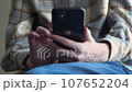frontal view a black iPhone in the hands of a girl. girl looking for information on the Internet using a smartphone, writing a message close-up 107652204