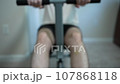 Man Working Out With Rowing Machine at Home 107868118