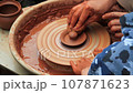 Pottery training. Making a clay pot on a potter's wheel. Manufacturing process. 107871623