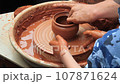 Pottery training. Making a clay pot on a potter's wheel. Manufacturing process. 107871624