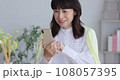 Middle senior touching a smartphone with a smile 108057395