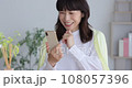 Middle senior touching a smartphone with a smile 108057396