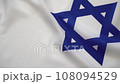 Man's hand puts Israeli international passports onto the Israeli flag 108094529