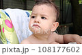 Portrait of a little boy who sits on a child's chair. Happy child drinks milk, kefir or dairy products from a cup. Correct and natural nutrition for children 108177602