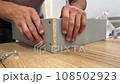 Assembling furniture with men's hands 108502923