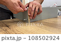 Assembling furniture with men's hands 108502924