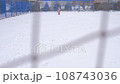 Siblings, 5 years old sister and 3 years old brother enjoying winter day on a fenced sports ground. Fun winter holidays. Playing with snow in a beautiful snowfall. Holiday outdoors in cold winter 108743036