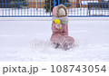 5 years old girl enjoying winter day on a fenced sports ground. Fun winter holidays. Playing with snow in a beautiful snowfall. Holiday outdoors in cold winter 108743054