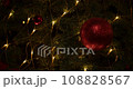 Close up of a red glittering ball hanging on a Christmas tree 108828567