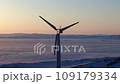Wind turbines at sunrise in heavy fog. Wind farm generating green energy 109179334