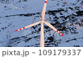 Wind turbines at sunrise in heavy fog. Wind farm generating green energy 109179337